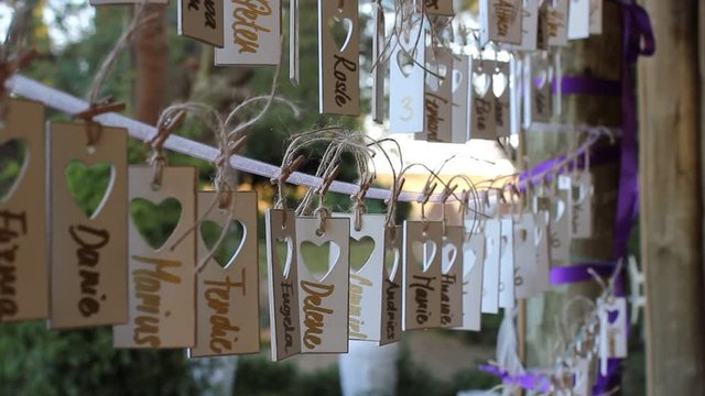 DIY name tags hanging ons string with the wind blowing through at a wedding close-up