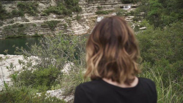 Woman standing by waterfall in Nature Reserve Cavagrande in Sicily