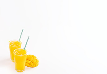 Fresh tropical mango juice with beautiful diced pulp and striped paper straw isolated on white background table, close up, cut out, clipping path.