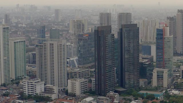 Panning Aerial View of Jakarta skyline during sunset. Tall buildings, polluted Air and dense populated city