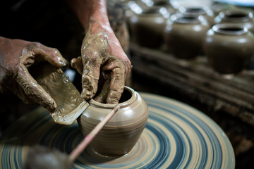 The old man's hands were molding clay pots.