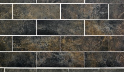 Black and brown horizontal wall tile pattern with a dark and marbled appearance.