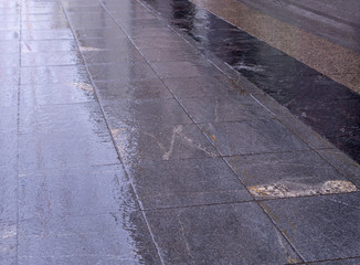 wet tiled sidewalk pavement at rainy day. background, texture.