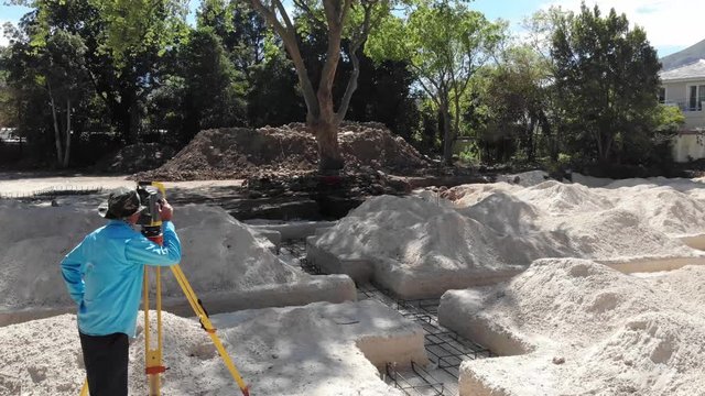 drone shot of a surveyor using survey equipment, a robotic total station theodolite on a construction site