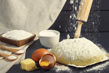 Yeast dough and ingredients for its preparation close-up, front view