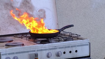 Fat burning in pan on a stove in the kitchen, kitchenfire demonstration