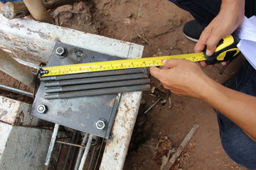 Technicians use tape measure to measure the size of the steel sheet used in construction
