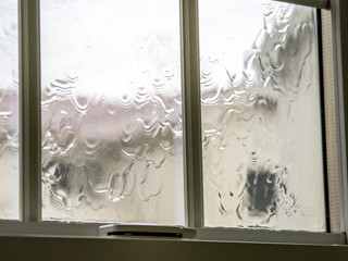 台風の激しい風雨で濡れた窓ガラス