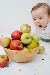 Close up portrait of baby boy playing with juicy apples