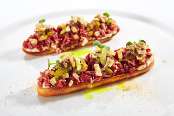 Beef Tartare on Toast with Black Garlic Cream Isolated