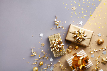 Golden gift or present boxes with golden bows and confetti top view. Christmas background. Flat lay...