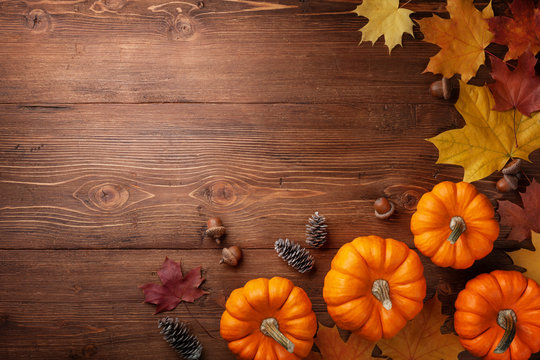 Autumn Thanksgiving background. Pumpkins, acorns and leaves on rustic table top view.