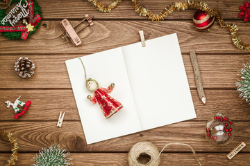 Top view of blank notebook on wood  background with xmas decorations. Mockup Christmas background with notebook for wish list or to do list. Flat lay with copy space.