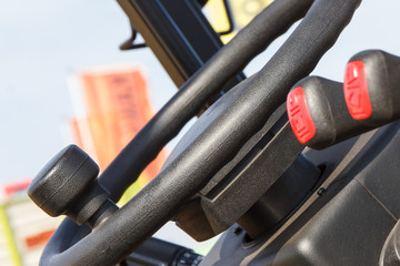 Operating control levers and steering wheel in loader machine