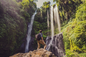 Man in turquoise dress at the Sekumpul waterfalls in jungles on Bali island, Indonesia. Bali Travel Concept © galitskaya