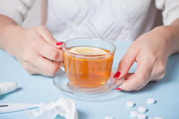 Woman holding cup of tea with piece of lemon. Health and traditional medicine concept