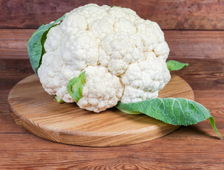 Fresh cauliflower head on the wooden serving board