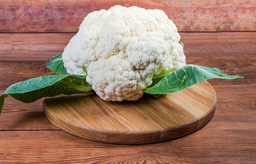 Head of freshly harvested cauliflower on a wooden surface