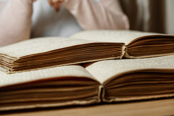 woman reading braille text on old book