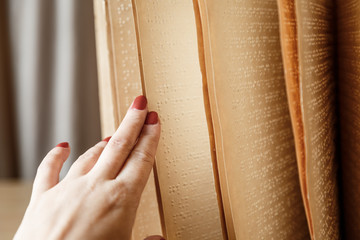 woman reading braille text on old book