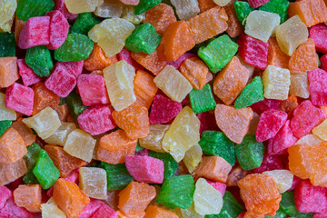 Background candied colorful fruit. Dried pineapple bits. Colored dried tropical fruit. Close up