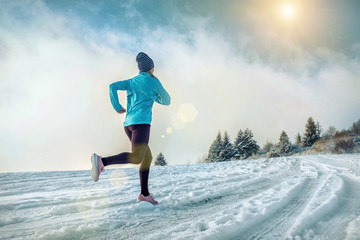 Running woman. Runner on the snow in winter sunny day. Female fi