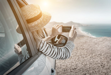 Happiness young woman sitting in white car and shoot with her ph