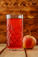Glass with lingonberry juice on a wooden table. Nearby lies an apple © vladimir pb