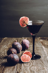 Martini cocktail with black vodka and figs on the rustic background. Selective focus. Shallow depth...