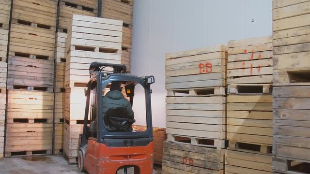 loader rearranges boxes with apples
