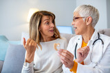 Modern hearing aids.The choice of hearing aid in the doctor's office. Doctor showing hearing aid. Otolaryngologist giving hearing aid to patient. The hearing aid for a senior woman