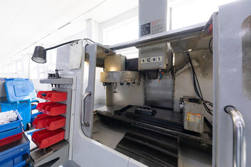 New computerized factory equipment processing metal parts inside factory building