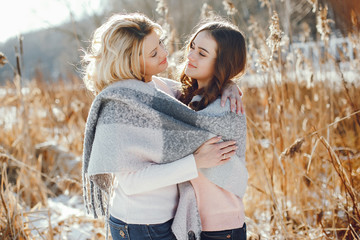 Fototapeta premium young blonde mom with her grown up daughter in the spring park