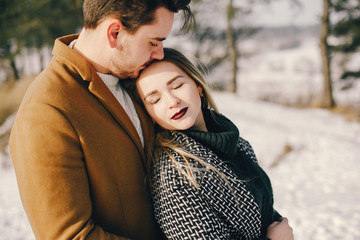 Fototapeta premium happy young couple walking through the park on a snowy day