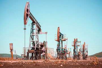 Oil pump jack rocking with pipeline in the background. Rocking machines for power generation....