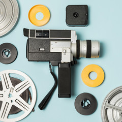 Camcorder and film reels cases on blue background