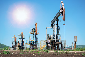 Oil pump jack rocking with pipeline in the background. Rocking machines for power generation....