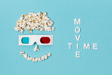 Movie time text with smiley anthropomorphic face made with popcorns and 3d glasses