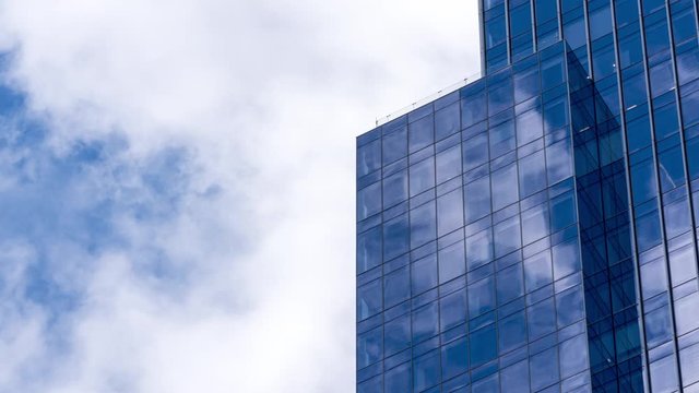 4K UHD Time lapse of cloud with blue sky and windows reflection in high building. Business and development concept.