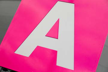 Close-up of white letter A on pink background