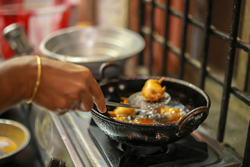 Woman Standing Her Kitchen Holding Spoon Preparing Snacks, fried onion bhajis