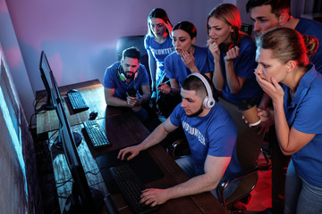 Young people playing video games on computers indoors. Esports tournament
