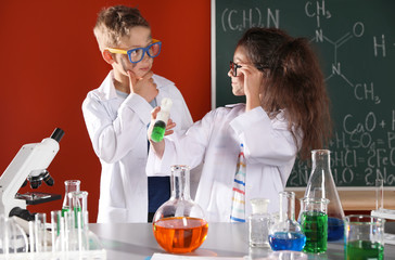 Children doing chemical research in laboratory. Dangerous experiment
