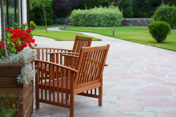 Wooden garden furniture on backyard near modern house