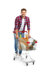 Young man with full shopping cart on white background