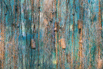 Hunting and fishing. Fish net drying in the sun..Colored turquoise background.