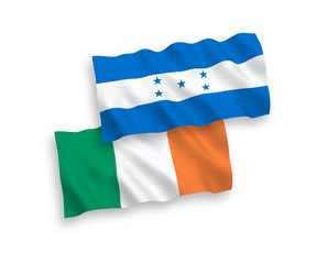 National vector fabric wave flags of Ireland and Honduras isolated on white background. 1 to 2 proportion.