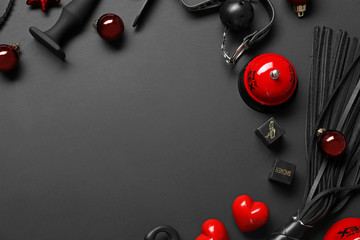 Frame made with different sex toys and Christmas balls on black background, flat lay. Space for text