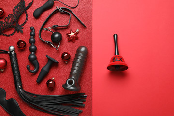 Set of different sex toys, Christmas decorations and bell on red background, flat lay