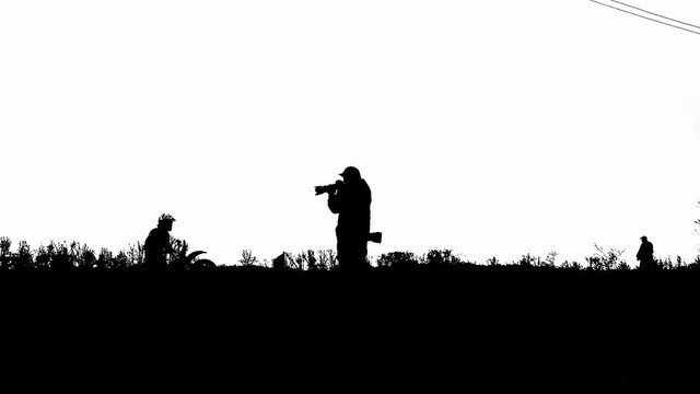 Silhouette of photographer taking pictures of a Bouncing motorcycle.